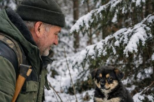 Лесник увидел в глубине густого леса маленького щенка, который сидел на мешке, будто охранял его.